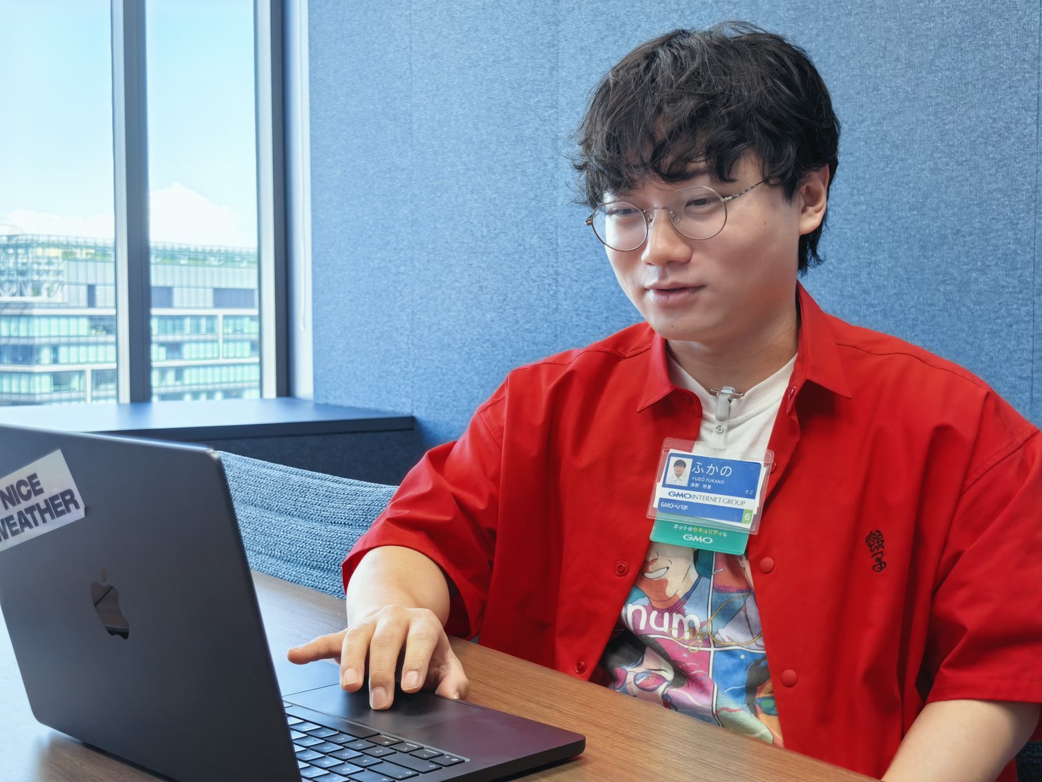 ノートPCを操作しながら今後の展望を語る深野さん。会議室の窓から外の景色が見える